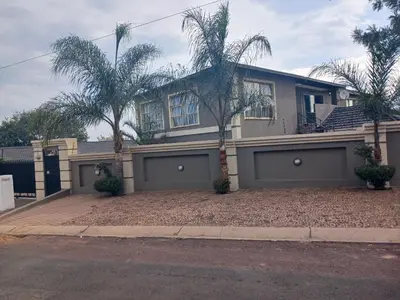 a house with two palm trees in front of it at Hilo guesthouse in Witbank