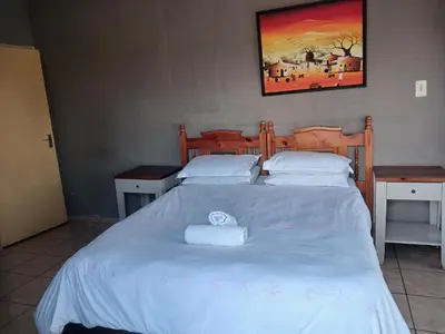 a bedroom with a bed with two white towels on it at Hilo guesthouse in Witbank