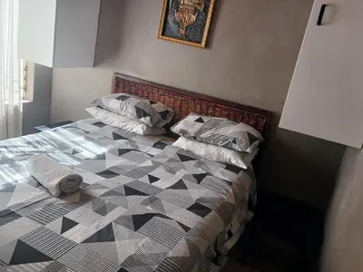 a bedroom with a bed with a black and white quilt at Hilo guesthouse in Witbank
