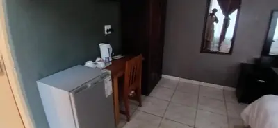 a small kitchen with a sink and a refrigerator at Hilo guesthouse in Witbank