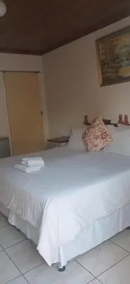 a white bed with a pillow on top of it at Hilo guesthouse in Witbank