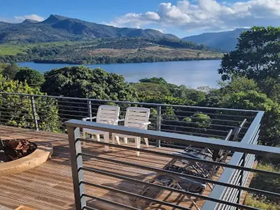 two chairs on a deck with a view of a lake at Tshivhase Nature Reserve in Vhutandabos