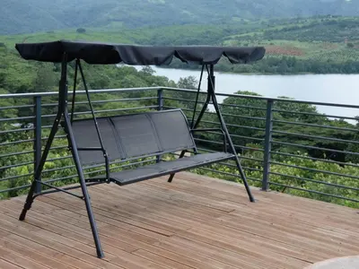 a swing on a deck with a view of a lake at Tshivhase Nature Reserve in Vhutandabos
