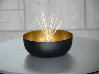 a black and gold bowl with sticks in it on a table at Tshivhase Nature Reserve in Vhutandabos
