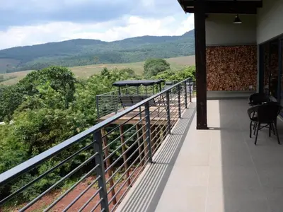a balcony of a house with a view of the mountains at Tshivhase Nature Reserve in Vhutandabos