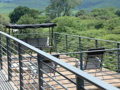 a balcony with a table and an umbrella at Tshivhase Nature Reserve in Vhutandabos