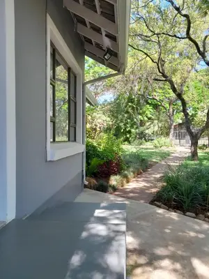 a white house with a window and a sidewalk at Ebenezer Self Catering in Groblersdal