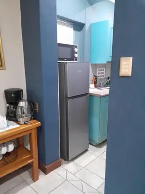 a kitchen with blue walls and a refrigerator and a table at Ebenezer Self Catering in Groblersdal