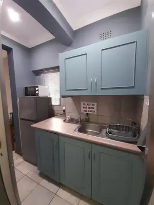 a kitchen with blue cabinets and a sink at Ebenezer Self Catering in Groblersdal