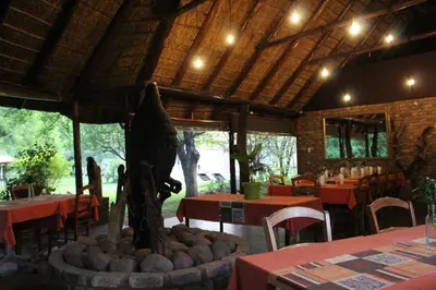 a restaurant with tables and chairs and a fountain in the middle at Tamboti Bush Lodge in Dinokeng Game Reserve
