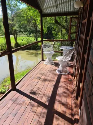 a porch with two chairs and a table on a house at Tamboti Bush Lodge in Dinokeng Game Reserve