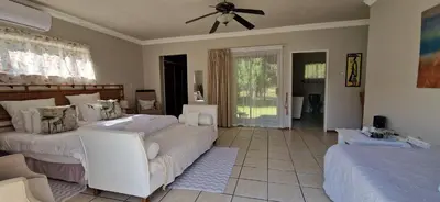 a bedroom with two beds and a ceiling fan at Tamboti Bush Lodge in Dinokeng Game Reserve