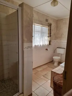 a bathroom with a shower and a toilet at Matumi Self Catering in Marloth Park