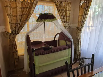 a baby crib in front of a window at Matumi Self Catering in Marloth Park