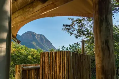 a view of a mountain through a wooden fence at Cape Vulture Lodge in Hoedspruit
