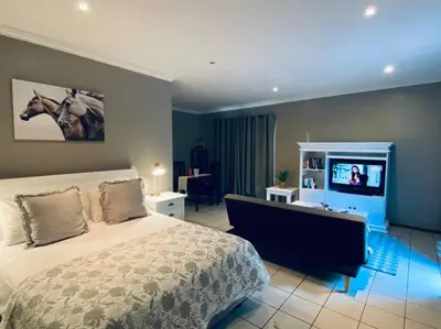 a bedroom with a bed and a flat screen tv at The Cottage at 152 in Centurion