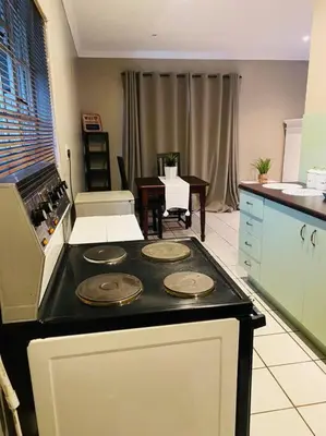 a kitchen with a stove top oven in a kitchen at The Cottage at 152 in Centurion