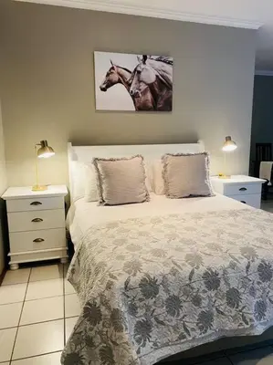 a bedroom with a bed with a horse picture on the wall at The Cottage at 152 in Centurion