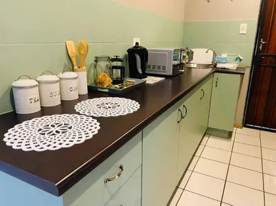 a kitchen with a counter top with a microwave at The Cottage at 152 in Centurion