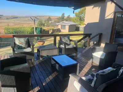 a porch with chairs and a table on a deck at Le Bella Dons in Graskop
