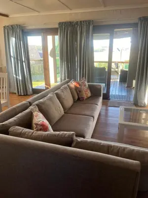 a brown couch in a living room with windows at Le Bella Dons in Graskop