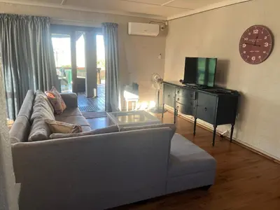 a living room with a couch and a tv at Le Bella Dons in Graskop