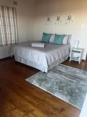 a bedroom with a large bed with blue pillows at Le Bella Dons in Graskop