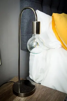 a lamp on a table next to a bed at Rock House at Benlize in Hartbeespoort
