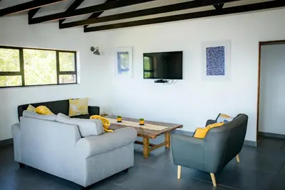 a living room with two chairs and a table at Rock House at Benlize in Hartbeespoort
