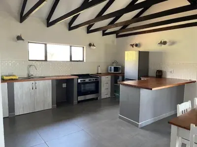 a large kitchen with a stove and a sink at Rock House at Benlize in Hartbeespoort