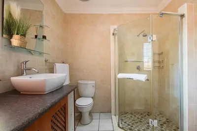 a bathroom with a sink and a toilet and a shower at Beautiful and Modern apartment close to Menlyn in Pretoria