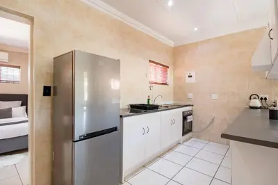a kitchen with a stainless steel refrigerator and a sink at Beautiful and Modern apartment close to Menlyn in Pretoria
