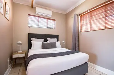 a bedroom with a large bed and a window at Beautiful and Modern apartment close to Menlyn in Pretoria