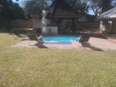 a swimming pool with a fountain in a yard at 15 On Reitz Bela bela in Bela-Bela