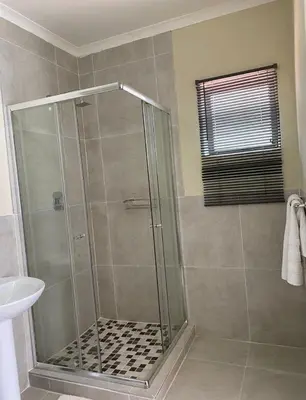 a shower stall with a glass door in a bathroom at Lime Court two in Pretoria