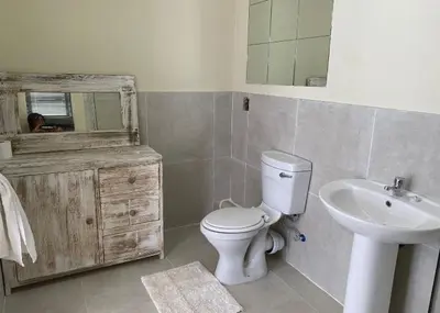 a bathroom with a white toilet and a sink at Lime Court two in Pretoria