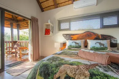 a bedroom with a bed with two giraffes on it at Call of the Fish Eagle Self-catering Holiday Home with solar in Marloth Park