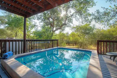 a swimming pool on the deck of a house at Call of the Fish Eagle Self-catering Holiday Home with solar in Marloth Park