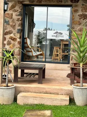 a bench sitting in front of a store window at Hazyview Accommodation, Bon Repose Cottage 2 in Hazyview