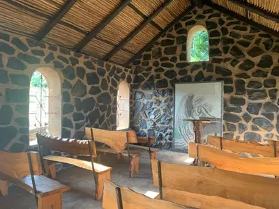 a room with wooden chairs and a stone wall at Hazyview Accommodation, Bon Repose Cottage 2 in Hazyview