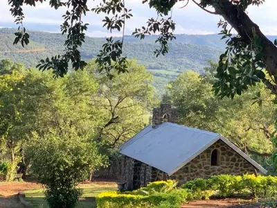 an old stone building with a white roof at Hazyview Accommodation, Bon Repose Cottage 2 in Hazyview