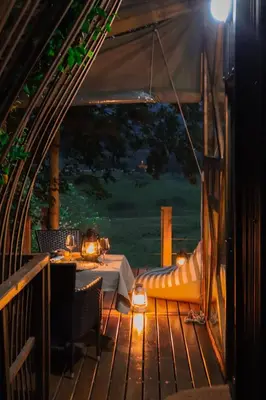 a patio with a table and a tent with a table and chairs at Quaint Luxury Villas in Graskop