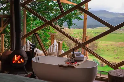 a bath tub in a room with a fireplace at Quaint Luxury Villas in Graskop
