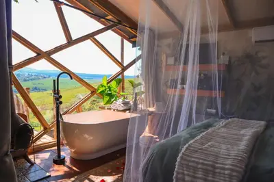 a bathroom with a large window with a bath tub at Quaint Luxury Villas in Graskop