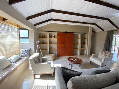 a living room with a couch and chairs and a table at Ostrich Hide in Marloth Park