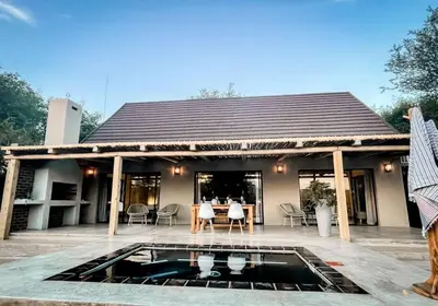a house with a swimming pool in front of it at UmnDeni Africa in Hoedspruit