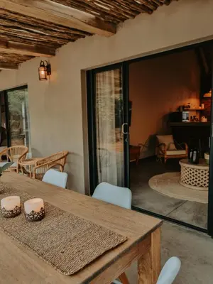 a dining room with a wooden table and chairs at UmnDeni Africa in Hoedspruit