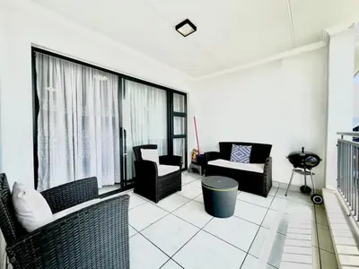 a living room with couches and chairs and a large window at TK’s Penthouse - The Blyde in Pretoria