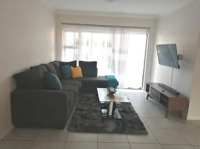 a living room with a couch and a table at TK’s Penthouse - The Blyde in Pretoria