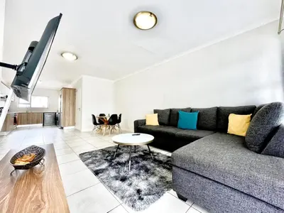 a living room with a couch and a table at TK’s Penthouse - The Blyde in Pretoria